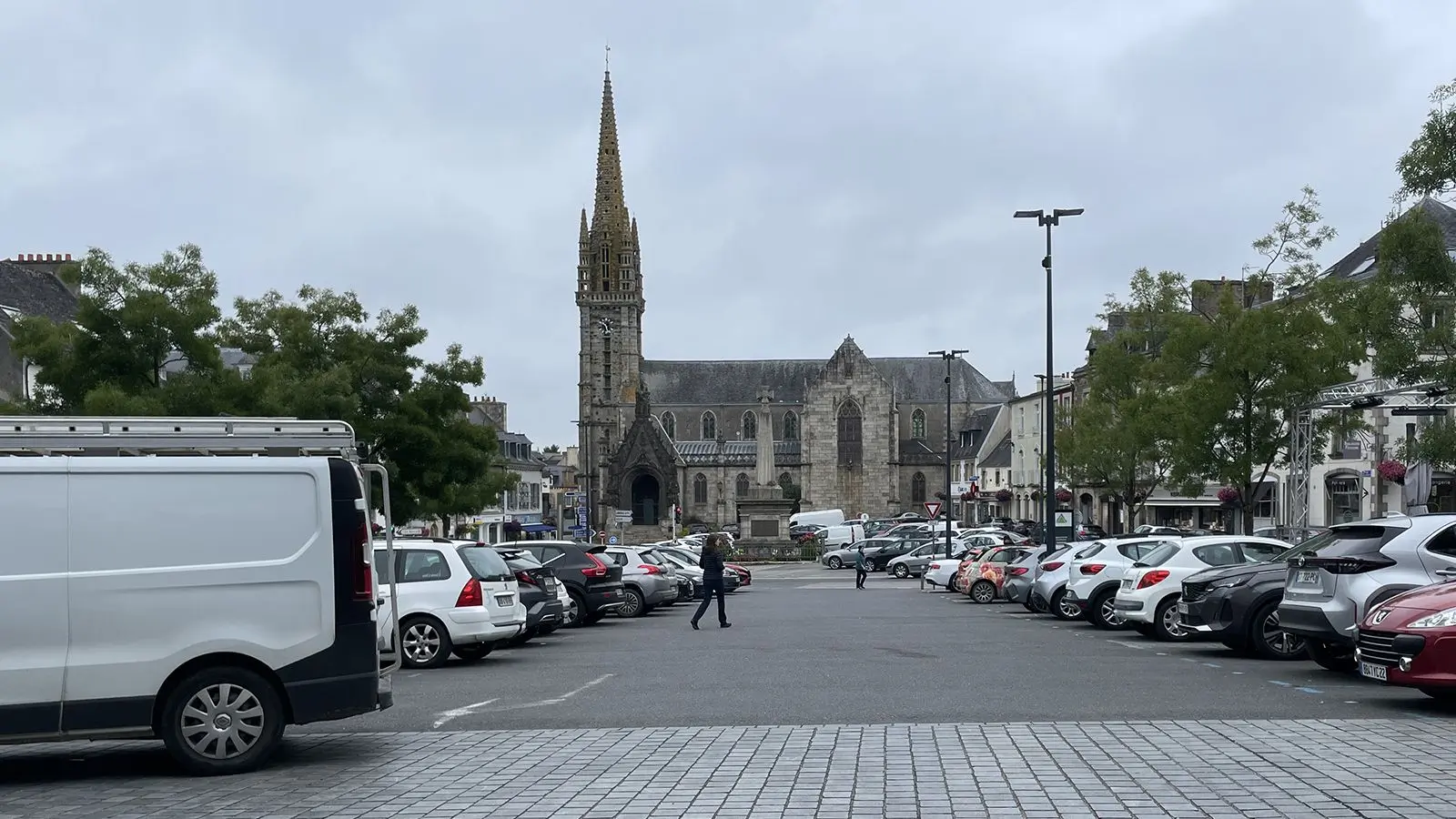 Place de l'église vue depuis la place des halles, avec une saturation de parking