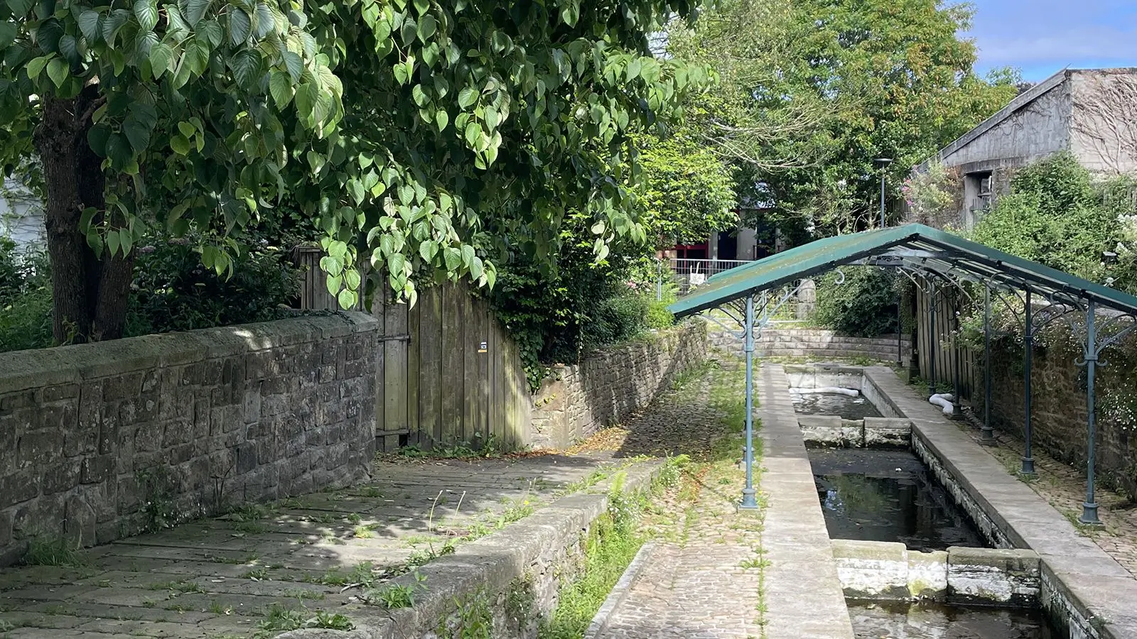 Le lavoir, résurgence de l'affluent du Lapic, dans une alcôve intimiste, rustique et arborée